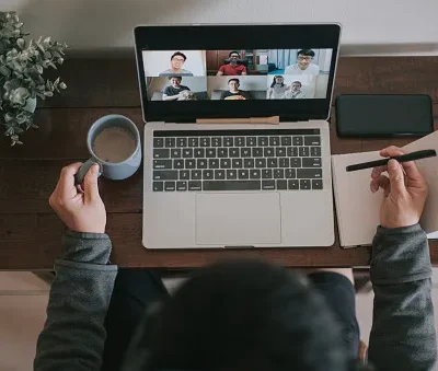 an asian chinese male working at home using laptop video conference call meeting with headset