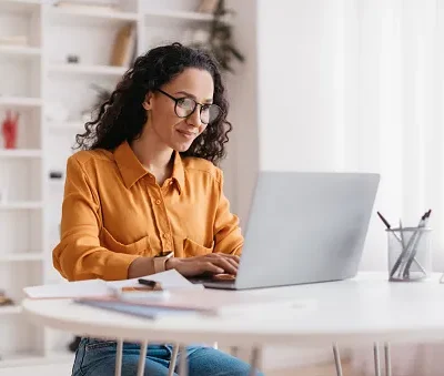 middle eastern lady using laptop working online sitting in office