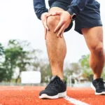 young man runner has sore knee because he ran too long male exercising until the injury
